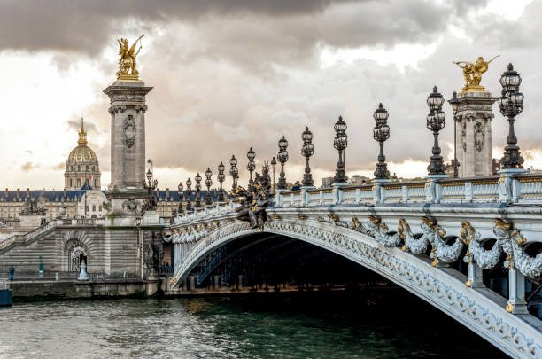 Scenic Alexander III bridge with ornate light posts and Dome des Invalides cathedral in a distance, Paris, France, autumn season, November 2017